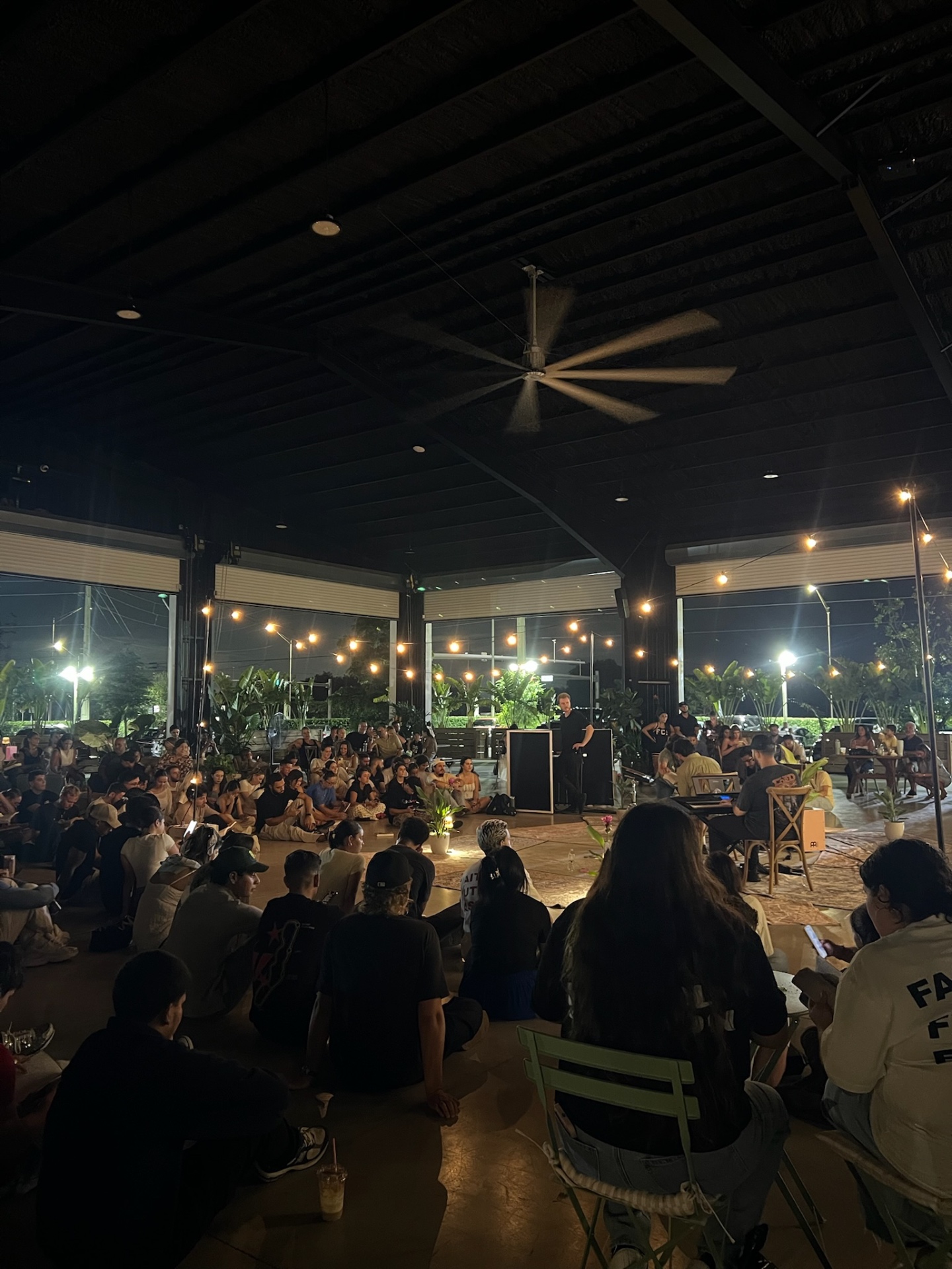 Community gathered to hear a message under the string lights