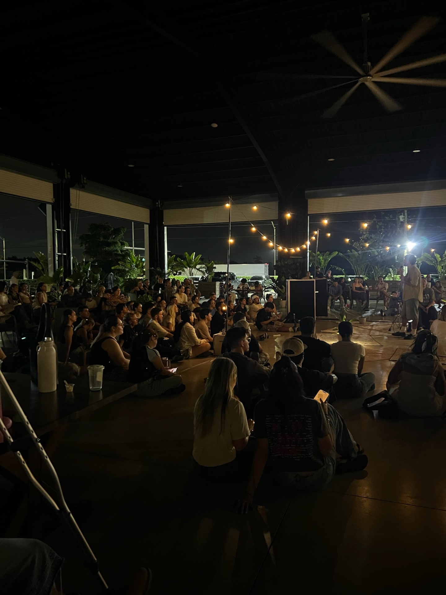 A speaker sharing a message with the seated community